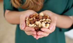 een vrouw die noten in der handen houdt
